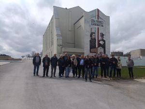 grupa ludzi przed budynkiem cukrowni