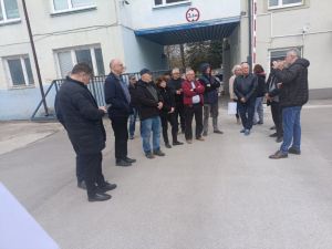 grupa ludzi przed budynkiem cukrowni